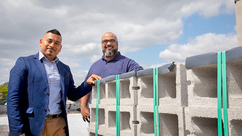 Associate Pastor Sergio Nava and Senior Pastor Esdras Ferreras stand with construction materials for their new church.